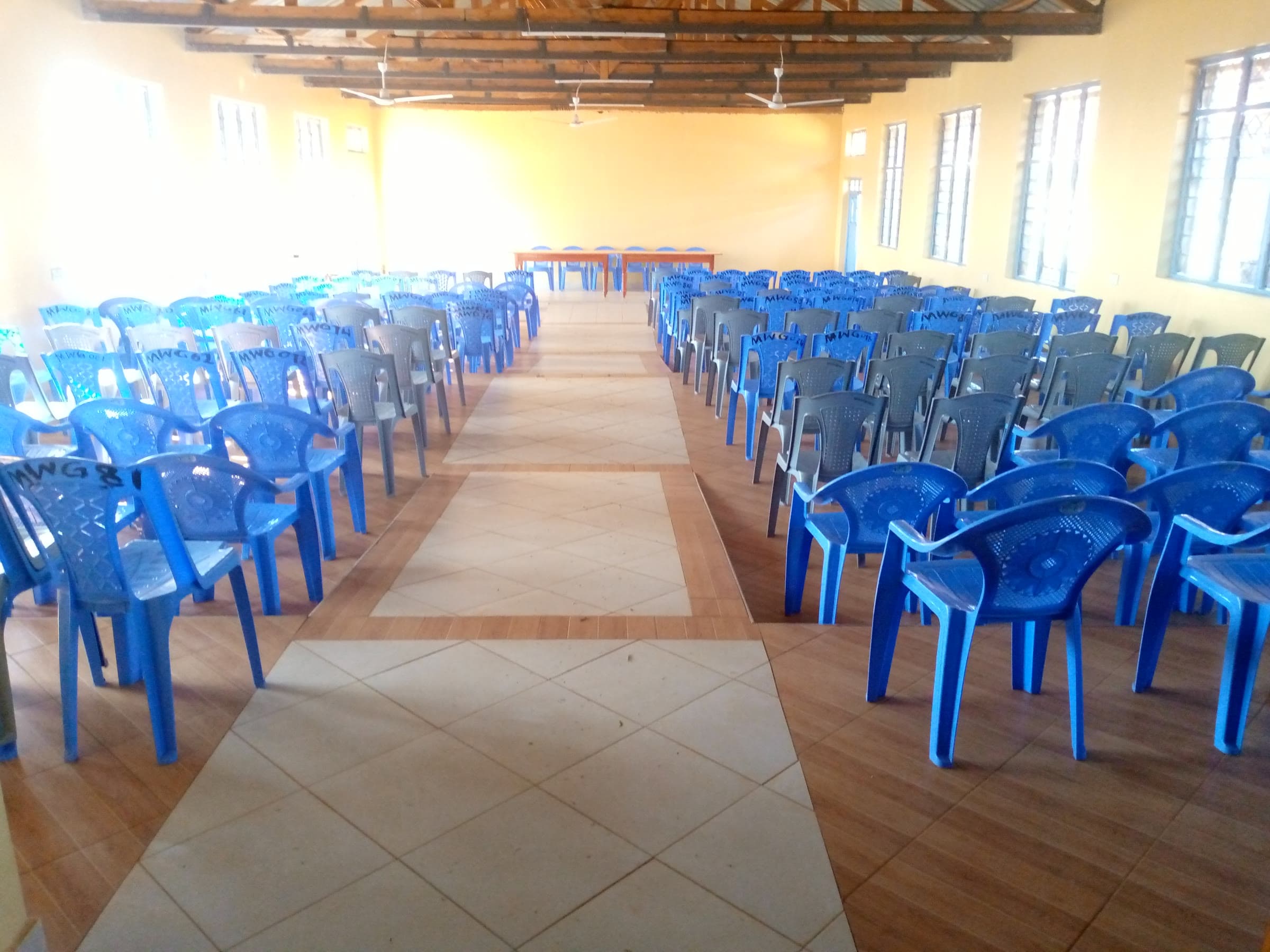 Blue chairs set out either side of the hall's tiled aisle