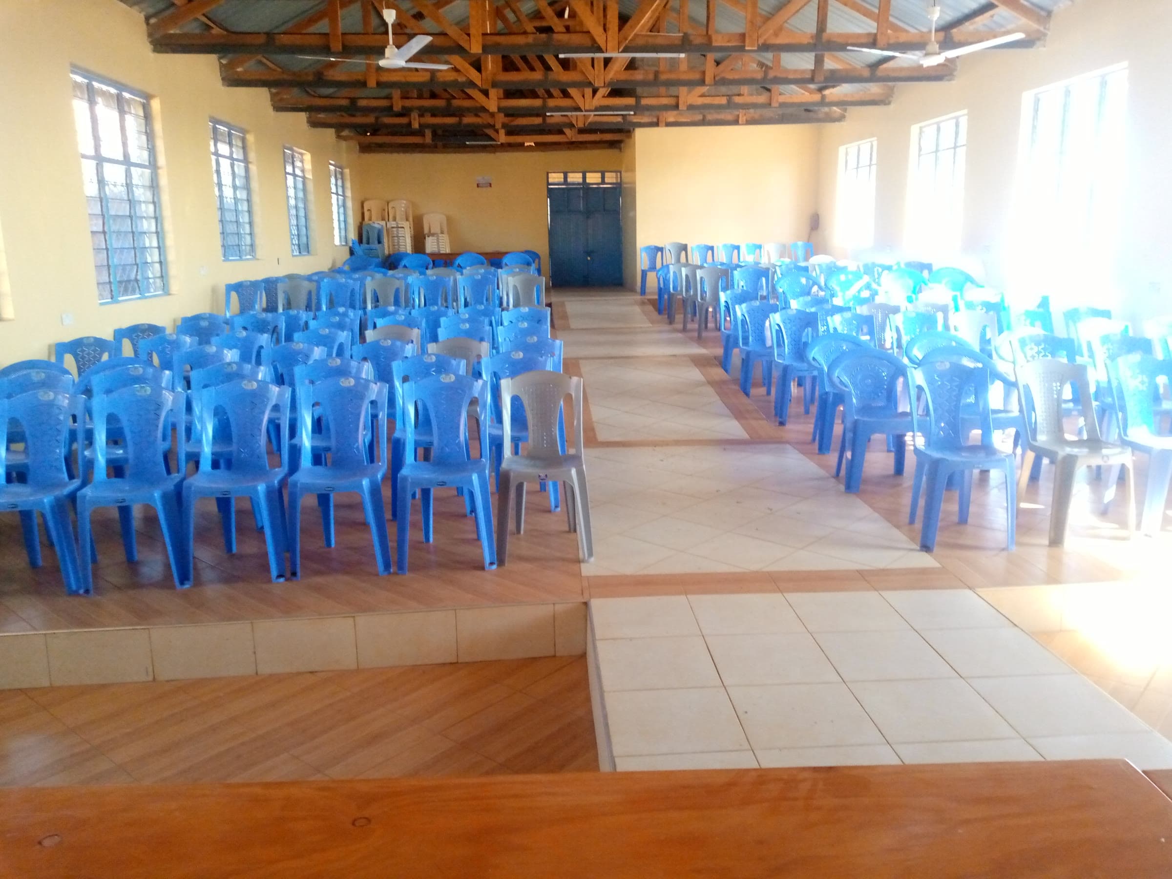 The hall from the raised platform, chairs either side of the aisle